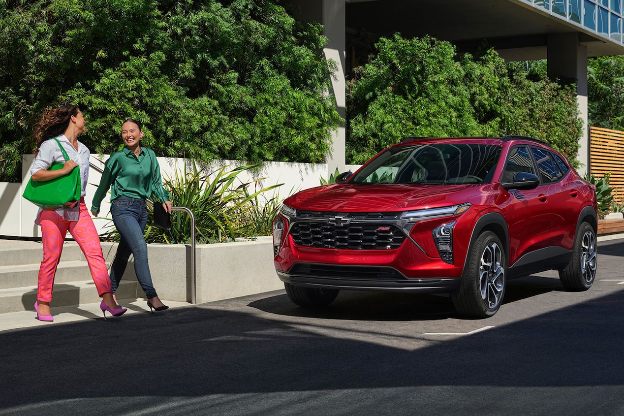 Woman leading her friend to her new 2024 Chevy Trax in Flint, MI