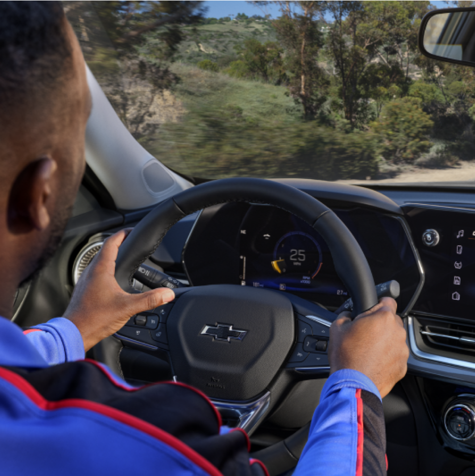 Man with hands on wheel driving 2025 Trax