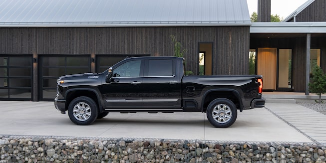 The 2024 Black Silverado HD Displayed Outside of A Modern Ranch Home