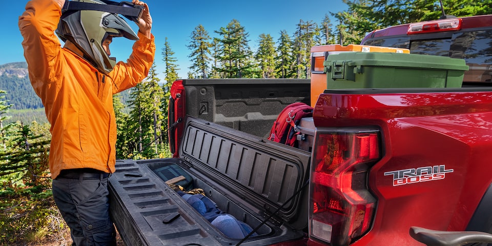 A Biker Grabbing his Gear from the StowFlex Tailgate of the Chevy Colorado 