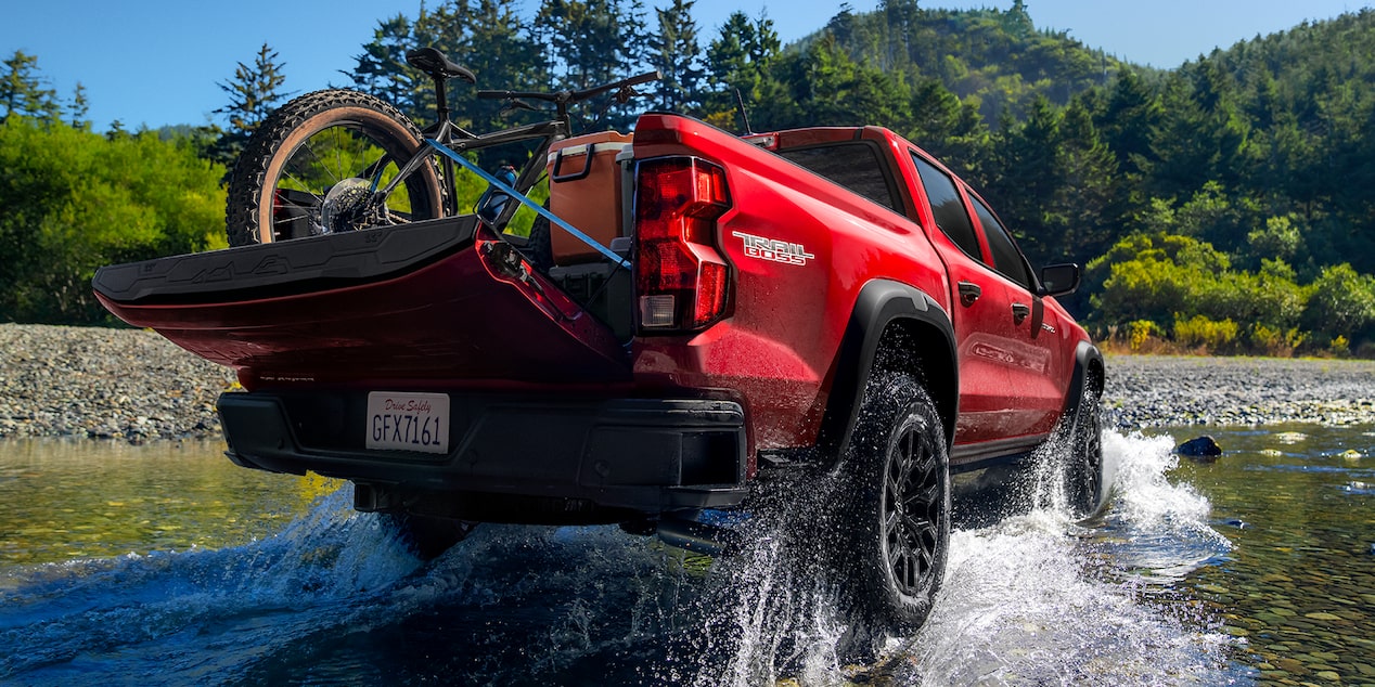 La Chevy Colorado circulando por un pequeño cuerpo de agua, con la caja de la camioneta cargada