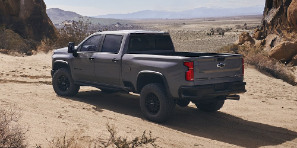 Toma de 3/4 del lado trasero del conductor de la Silverado HD estacionada en el desierto