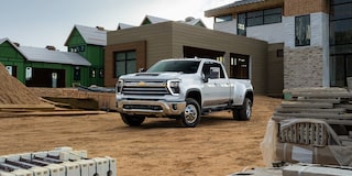 Front 3/4 View of Summit White 2024 Silverado HD Among Construction Materials