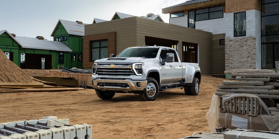 Front 3/4 View of Summit White 2024 Silverado HD Among Construction Materials