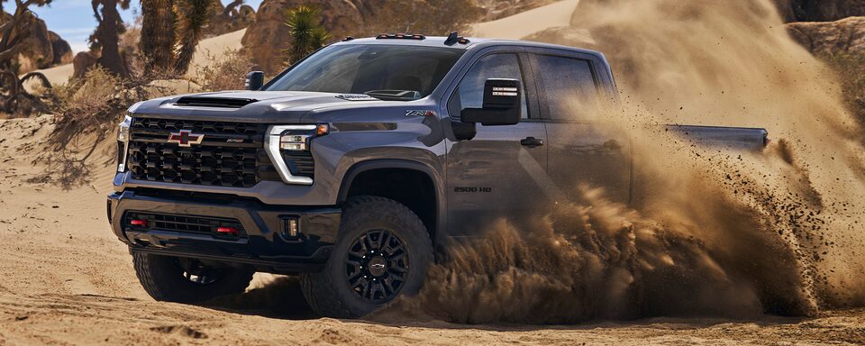 Driver's Side of Silverado HD ZR2 Driving in Dirt