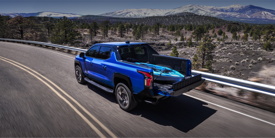 2024 Chevy Silverado EV Driving Down a Highway With A Kayak In The Bed