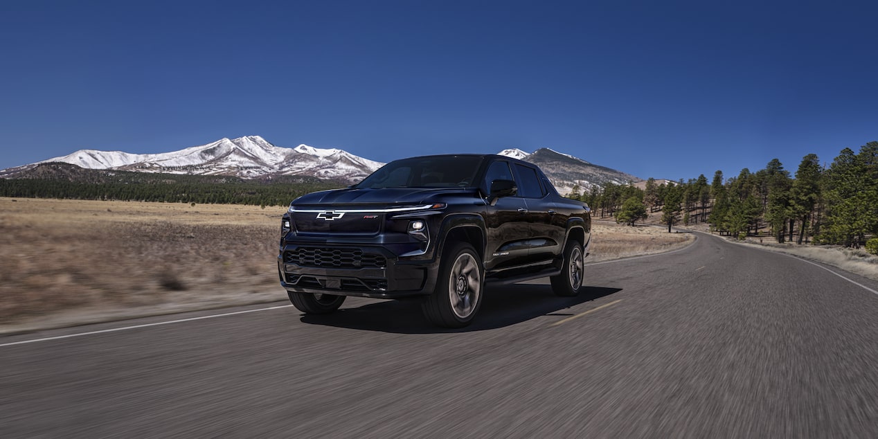 Vista de medio perfil de la parte delantera de la Silverado EV 2024 circulando por el bosque