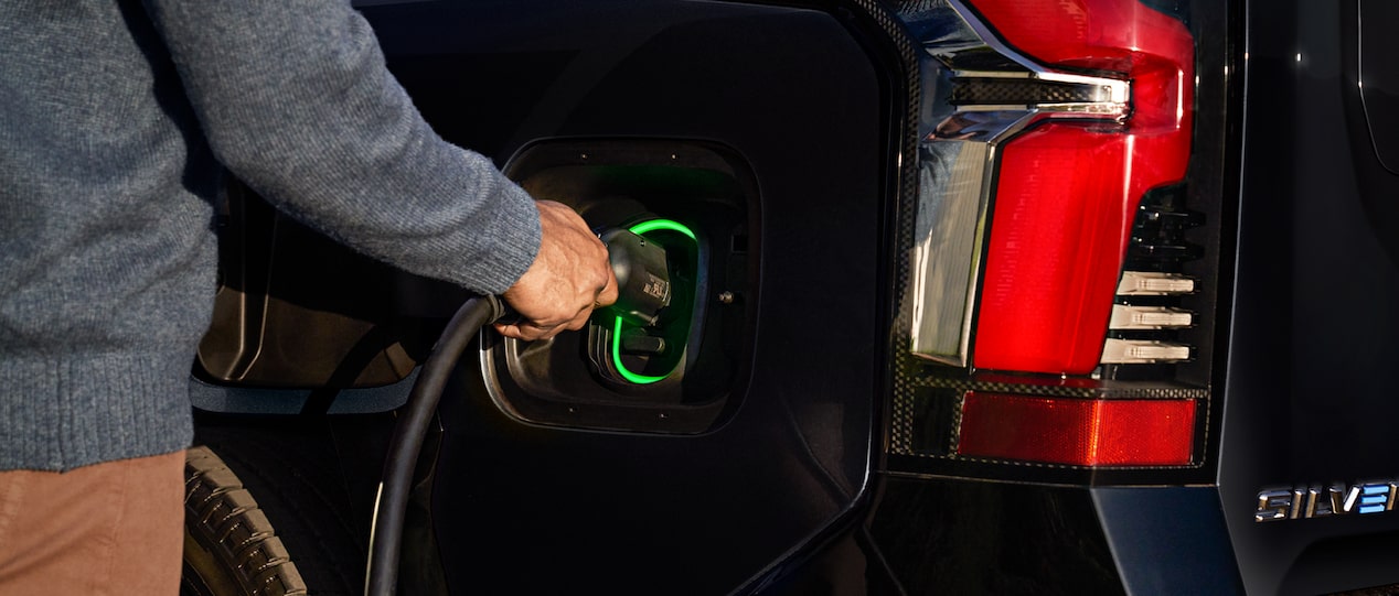 Driver Plugging in Their Chevy Silverado EV into the Charging Station