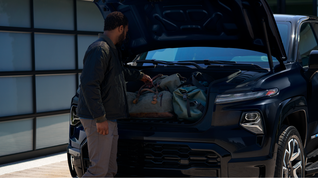 Man Loading the Front Interior Cargo Space Under the Silverado EV Hood