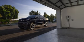2024 Chevy Silverado EV Parked Outside A Garage Plugged Into a Charging Port