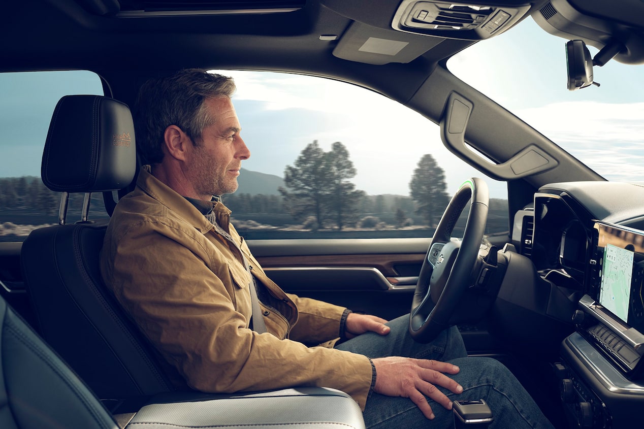 A Man Enjoying the Connected Services Technology of his 2024 Silverado