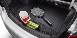 Vista aérea de la cajuela expuesta de una Chevy Malibu 2025 con una raqueta de tenis, pelotas y un termo