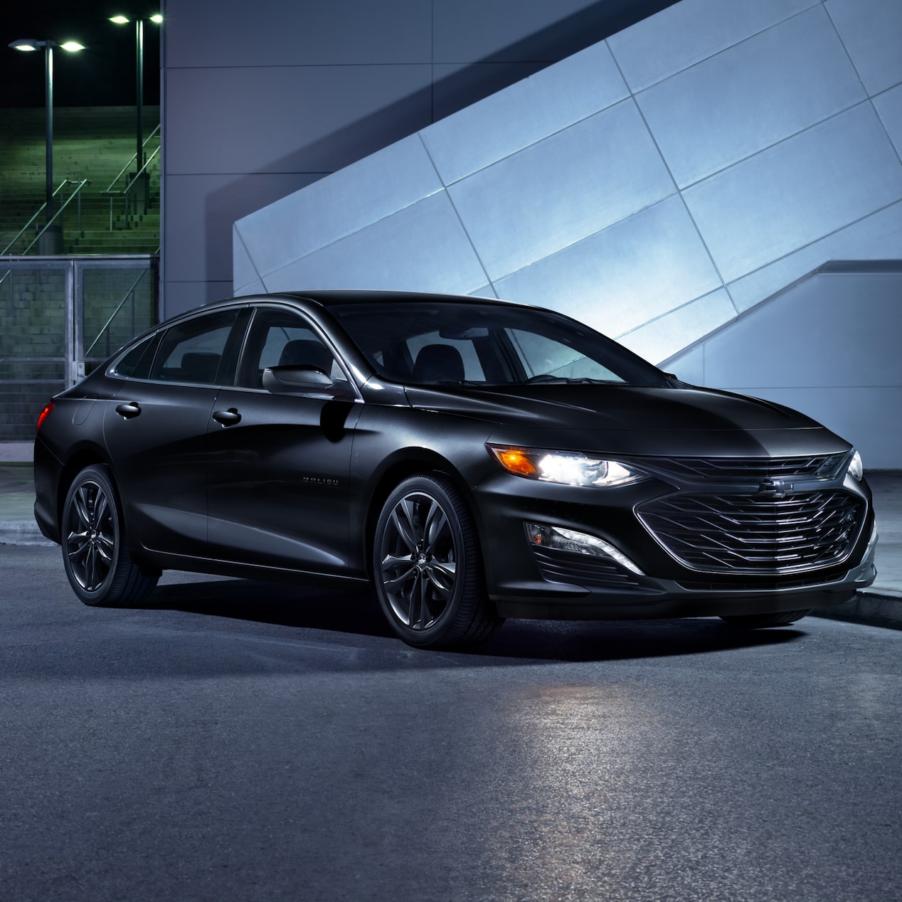 Stationed 2025 Midnight Edition Chevy Malibu at the Road Side with the Lights on