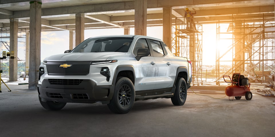 Vista de medio perfil de una Chevy Silverado EV con la luz solar que proviene desde atrás