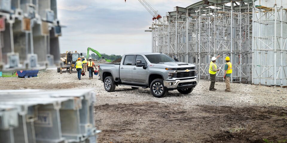 A 2025 White Chevy Silverado HD Truck in a Construction Site with Workers