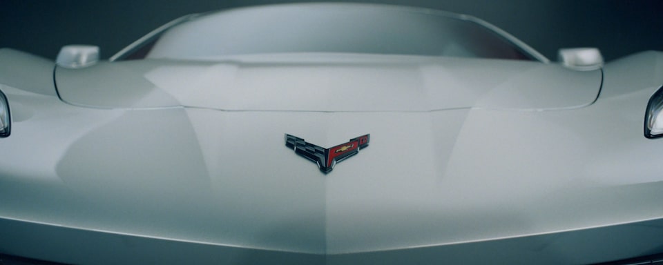 Primer plano del cofre delantero con el emblema de banderas cruzadas de un Chevy Corvette Z06 2025 de color Gris