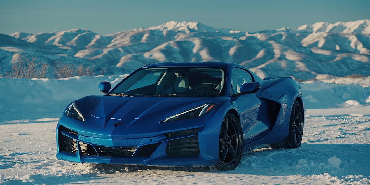 Vista de medio perfil de un Chevy Corvette E-Ray 2025 en Azul, en una planicie helada rodeada de montañas cubiertas de hielo