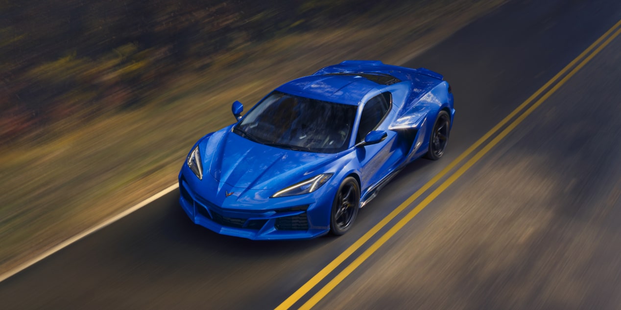 Vista aérea de un Chevy Corvette E-Ray en Azul circulando por un camino