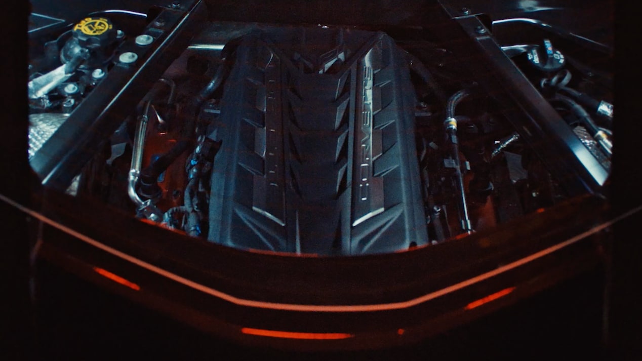 Un Chevy Corvette E-Ray en un entorno oscuro, con el cofre abierto y el motor expuesto