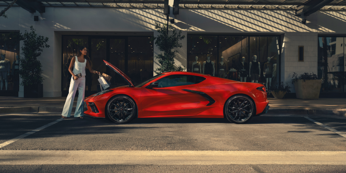 A Woman Lifted up the Front Hood of a 2025 Red Chevy Corvette Stingray