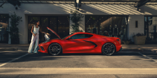 A Woman Lifted up the Front Hood of a 2025 Red Chevy Corvette Stingray