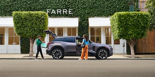 A Woman Is Seen Holding the Front Door and a Man Has Opened the Trunk of the 2025 Chevy Blazer EV