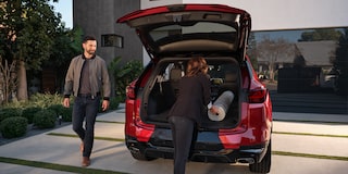 A Woman Putting a Mat Inside the Trunk of a 2025 Red Chevy Blazer