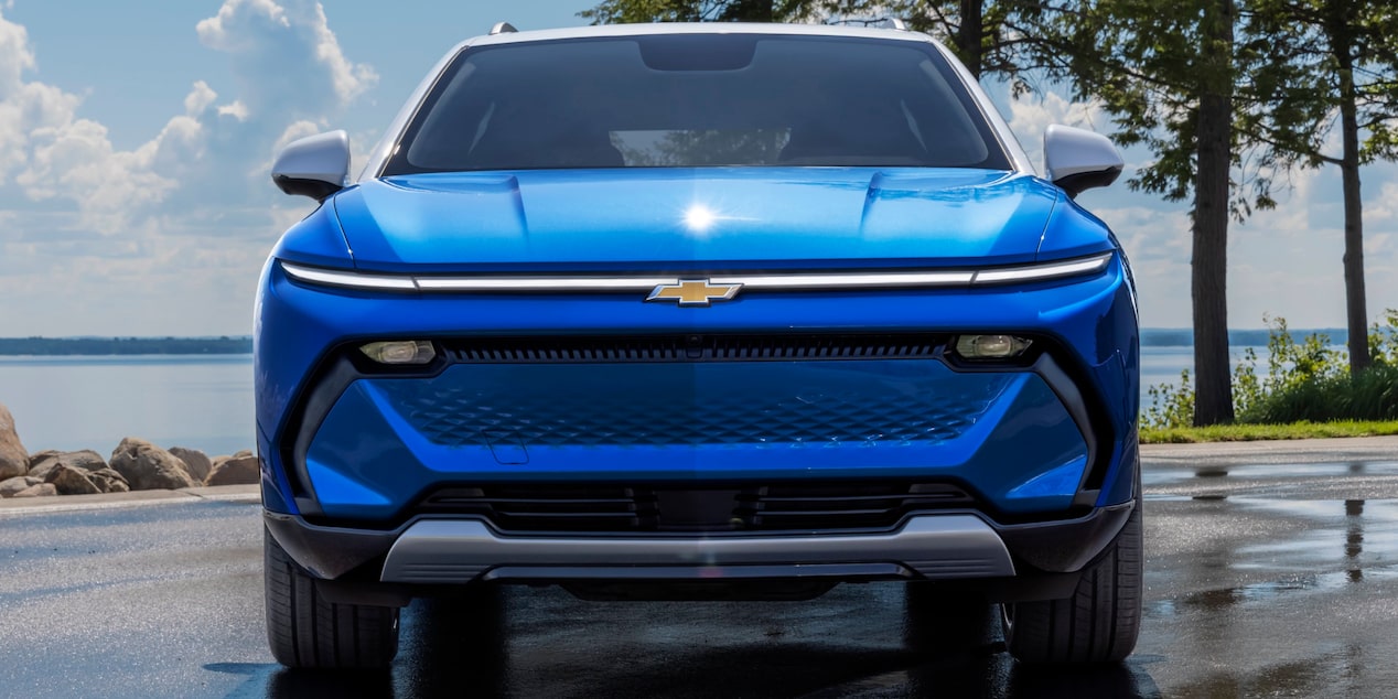Eye Level View of the Front of a Blue 2025 Chevy Equinox EV Close to a Body of Water