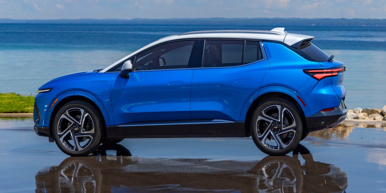 Side View of a Blue 2025 Equinox EV Next to a Beautiful Shoreline