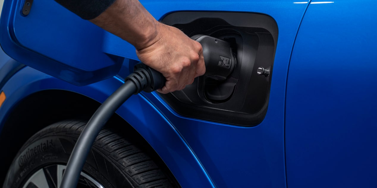 A Blue 2025 Chevy Equinox EV Is Getting Charged at a Station