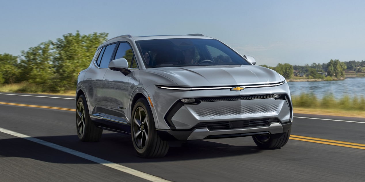 Three Quarters View of a Gray 2025 Chevy Equinox EV Driving Down the Road