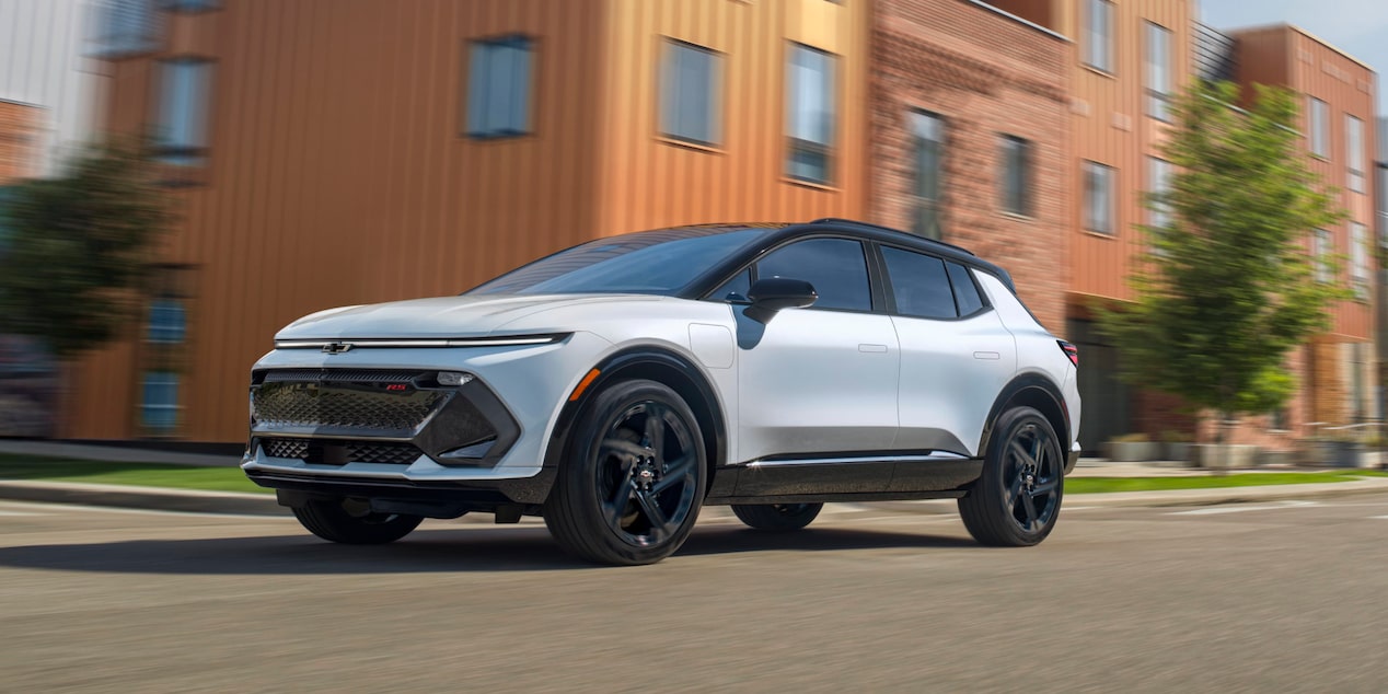 Low Three Quarters Rear View of a 2025 White Chevy Equinox EV Going down the Road
