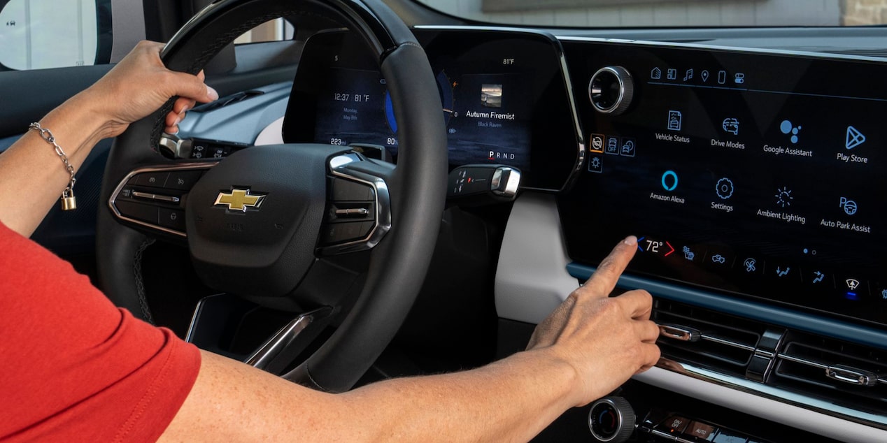 Close-up of the Dashboard Monitor of a 2025 Chevy Equinox EV with a Hand on the Steering Wheel