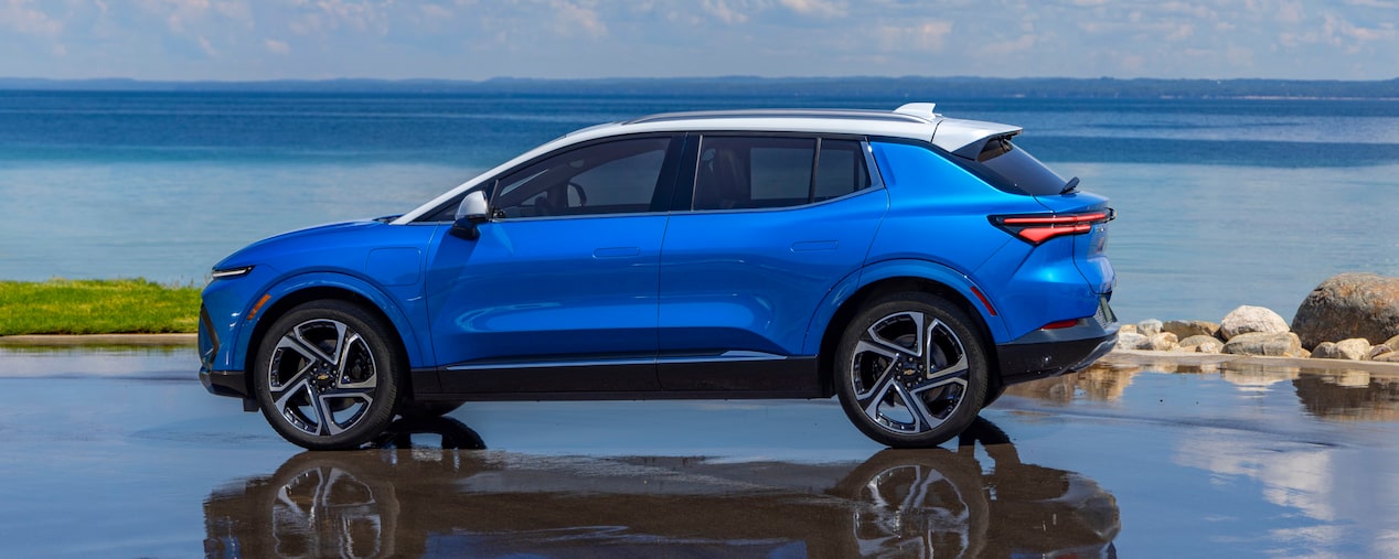 Side View of a Blue 2025 Equinox EV Next to a Beautiful Shoreline