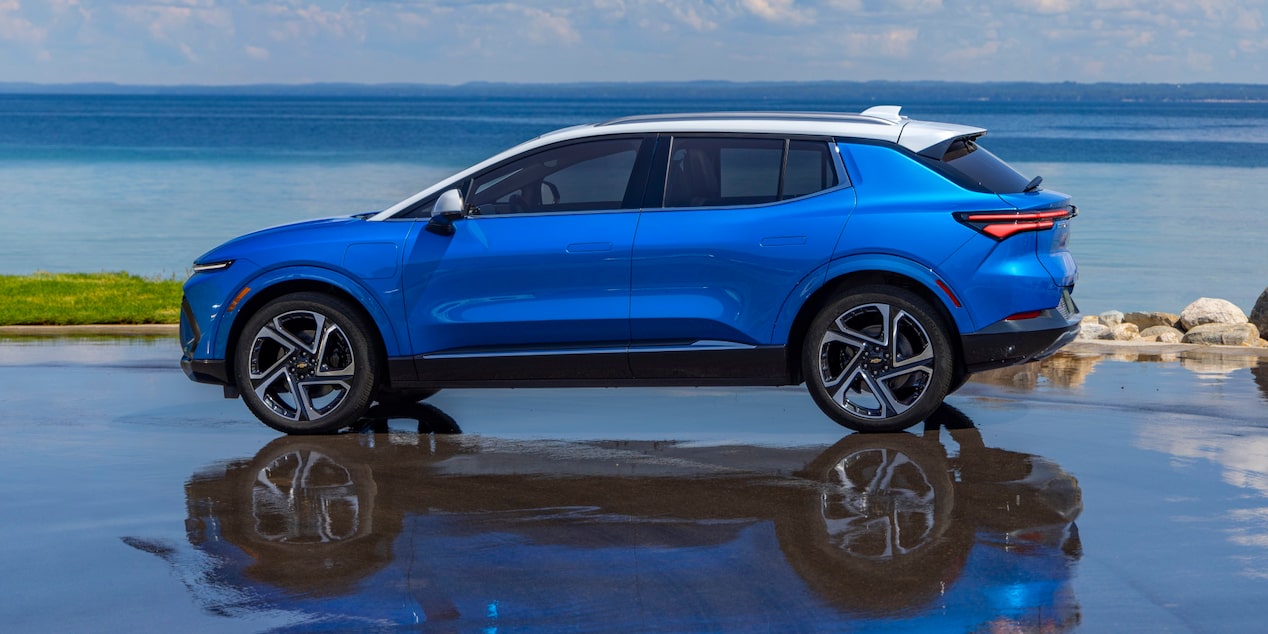Side View of a Blue 2025 Equinox EV Next to a Beautiful Shoreline