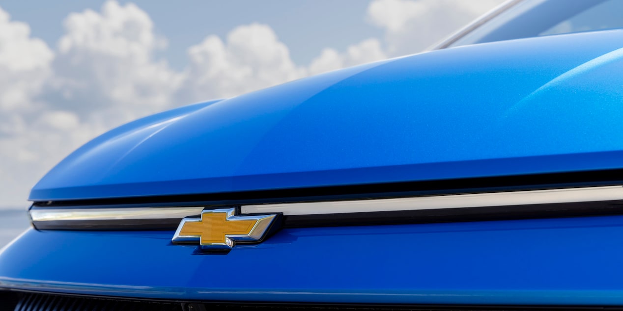 Close-up of the Chevy Emblem Infront of the Blue 2025 Chevy Equinox EV