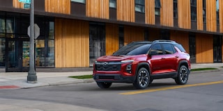 Una Chevy Equinox 2025 en Rojo frente a un edificio moderno