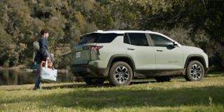Una persona de pie detrás de la Chevy Equinox 2025 con bolsas