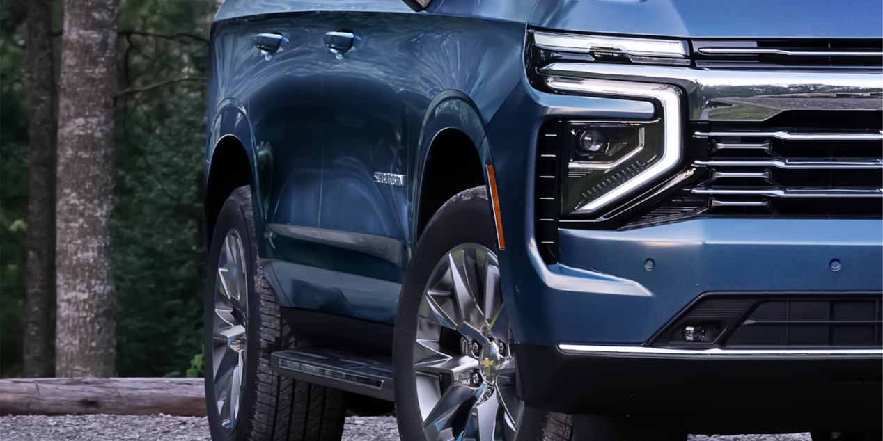 Close-up of the 2025 Chevrolet Suburban's Passenger Side Parked in a Wooded Area