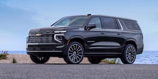 Front Three-Quarters View of the 2025 Chevrolet Suburban SUV Parked in Front of a Business