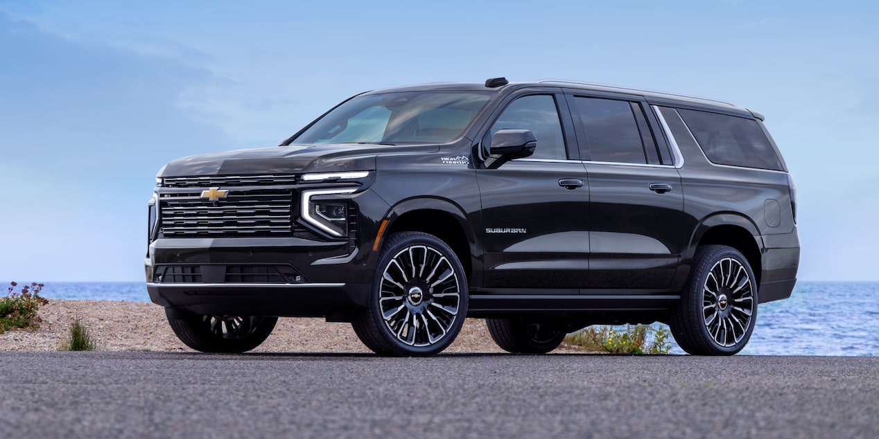 Front Three-Quarters View of the 2025 Chevrolet Suburban SUV Parked in Front of a Business