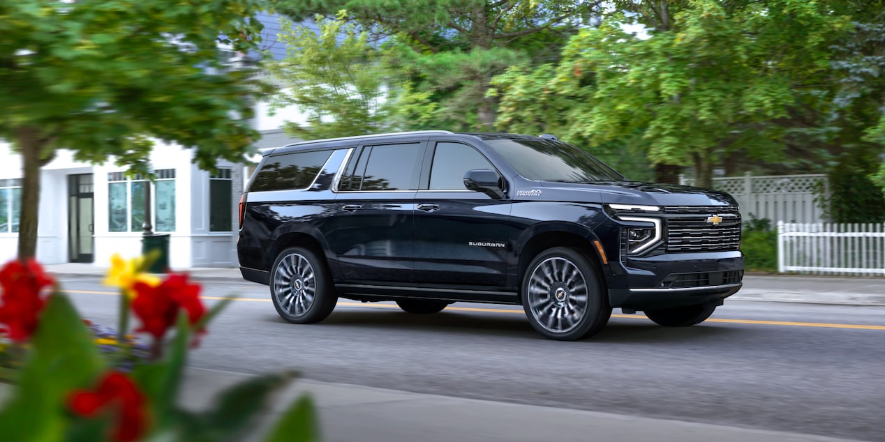 Front Three-Quarters View of the 2025 Chevrolet Suburban SUV Parked in a Wooded Area