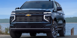 Vista frontal de tres cuartos de SUV Chevrolet Tahoe 2025 estacionada cerca de un lago