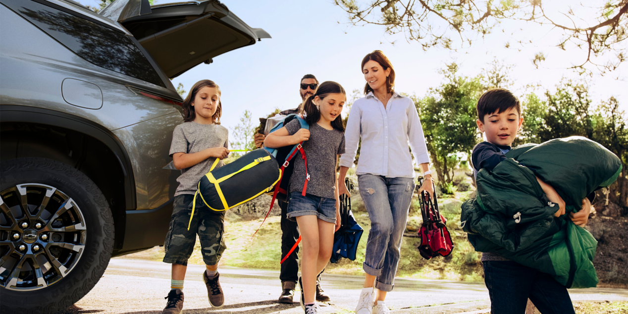 A Family Walking with Camping Gear from the 2025 Chevy Traverse Trunk