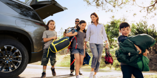 A Family Walking with Camping Gear from the 2025 Chevy Traverse Trunk