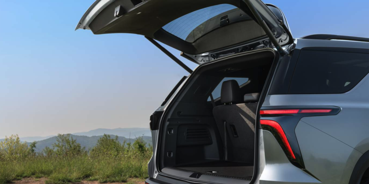 Side Rear View of the 2025 Chevy Traverse with Opened Trunk under Clear Blue Sky