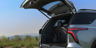 Side Rear View of the 2025 Chevy Traverse with Opened Trunk under Clear Blue Sky