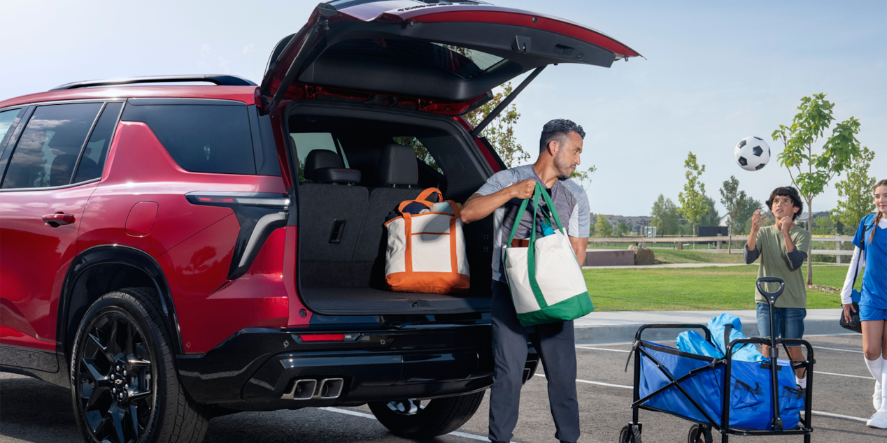 A Man Taking Out Bags from the Trunk of a Red 2025 Chevy Traverse