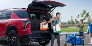 A Man Taking Out Bags from the Trunk of a Red 2025 Chevy Traverse
