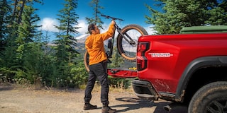 A Man Unloading his Bike from the Cargo Bed of his Chevy Colorado